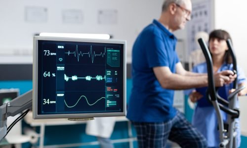 Close up of heart rate monitor measuring heartbeat for patient doing gymnastics for physical recovery. Retired man using sport equipment to exercise for physiotherapy and strength.
